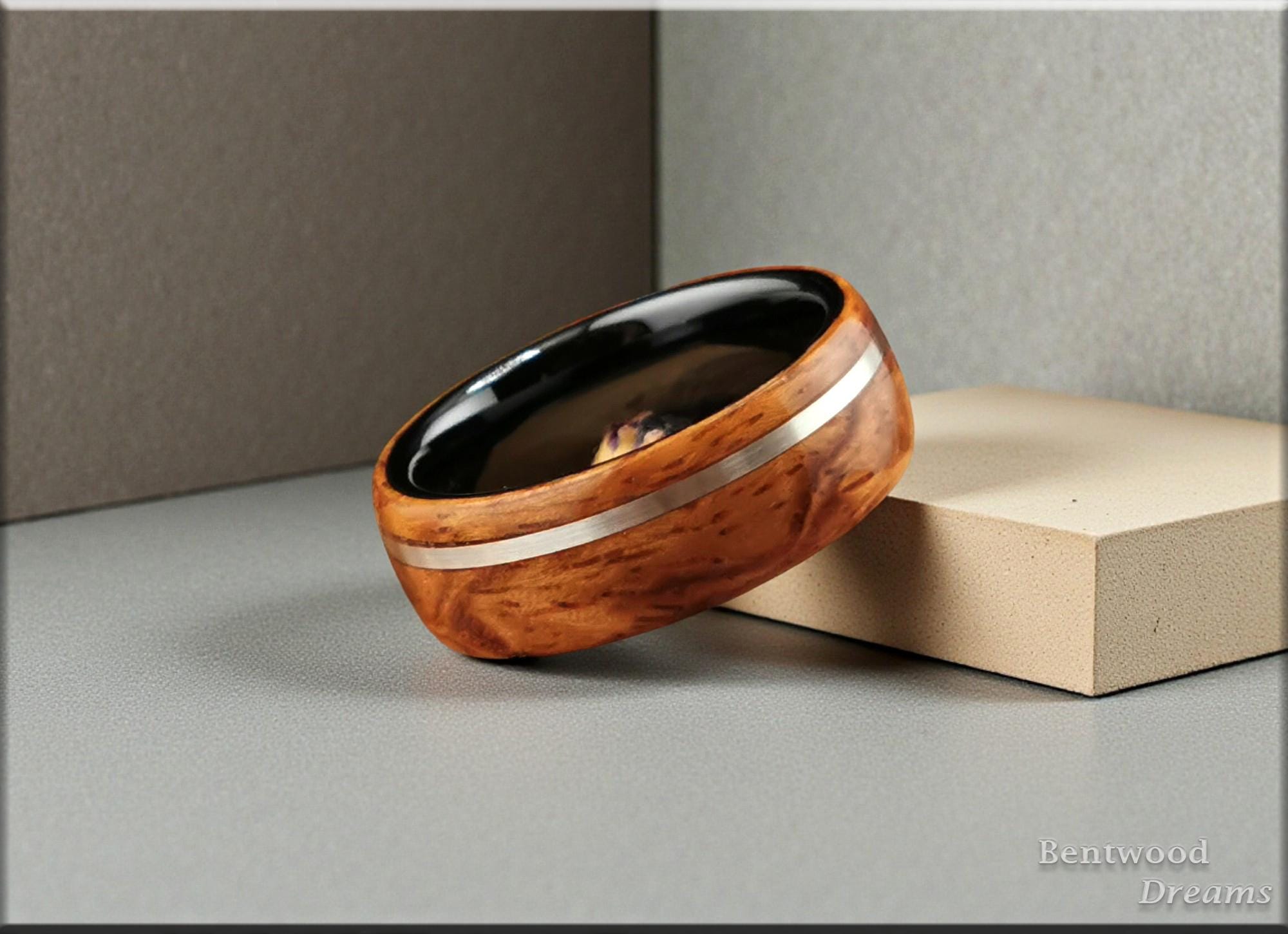 Bentwood Ring: Quilted Afzelia, offset inlaid Sterling Silver, Polished Black Ceramic core, wood ring